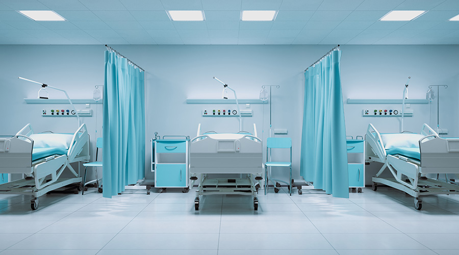 A row of medical beds in the hospital hallway. The line of empty beds. Hospital furniture. Clinic interior. Intensive care beds for semi-isolated patients. Emergency medical care in a crisis situation