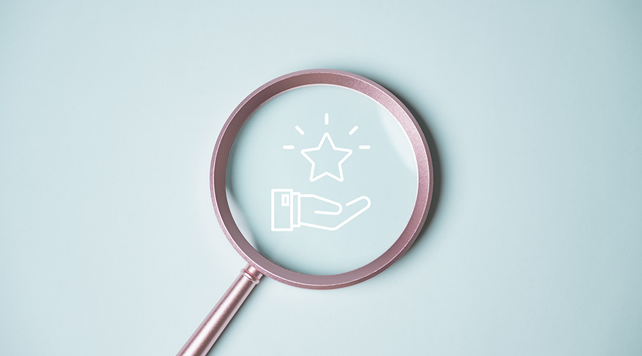 Minimal concept image of awards shown through magnifying glass icon with star and hand. Ideal for business, finance, customer retention, digital marketing, and reward.