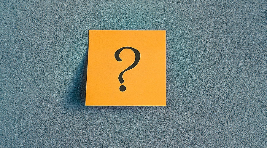 Hand-drawn question mark on an orange sticky note