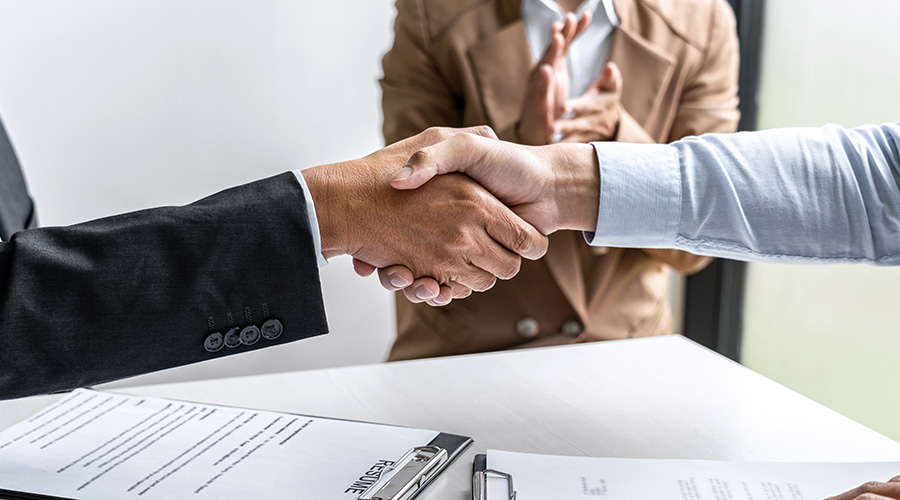 Greeting new colleagues, Handshake while job interviewing, male candidate shaking hands with Interviewer or employer after a job interview, employment and recruitment concept.